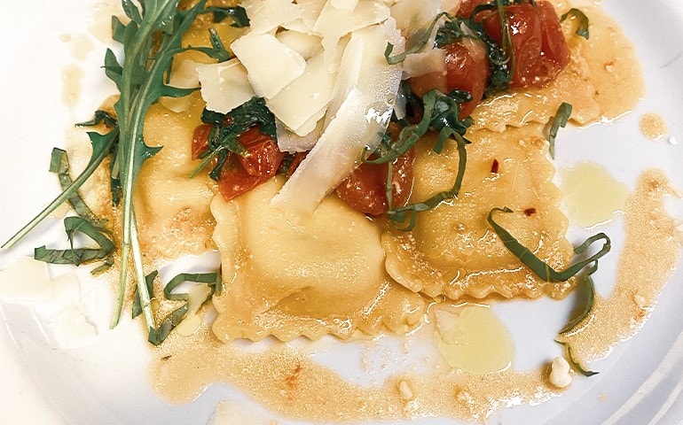 Ricotta and spinach ravioli with Pachino rocket and Parmesan cheese